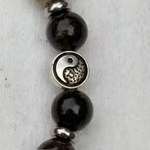 a close up of a bracelet with yin yang
