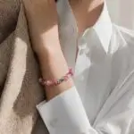 Person wearing bracelet with pink beads